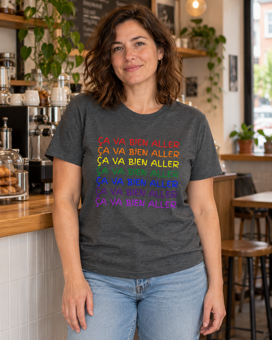 T-shirt Ça va bien aller gris foncé chiné, motif multicolore, porté dans un café.