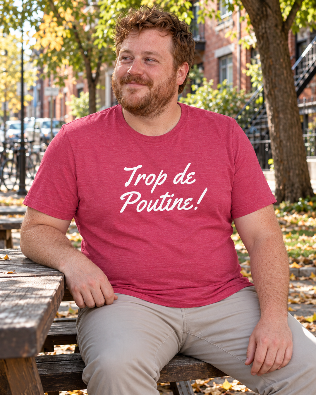 T-shirt Le lifestyle framboise chiné à logo blanc Trop de Poutine, porté avec un pantalon beige au parc.